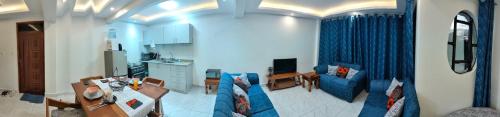 sala de estar con sofá azul y cocina en Kesuiyo Loft en Nairobi