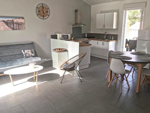 une cuisine et un salon avec une table et des chaises dans l'établissement La Petite Dune 800m de la Plage, à Bretignolles-sur-Mer