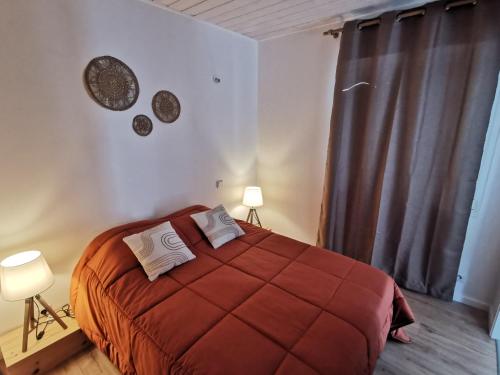 - une chambre avec un grand lit rouge et 2 oreillers dans l'établissement La Petite Dune 800m de la Plage, à Bretignolles-sur-Mer