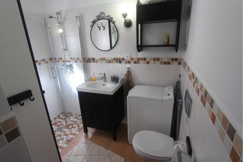 y baño con lavabo, aseo y espejo. en Ferienhaus Casa Corsica, en Linguizzetta