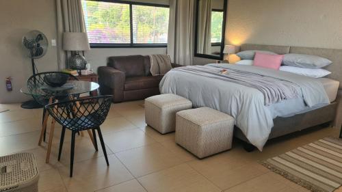 a bedroom with a large bed and a couch at One85 in Vinko in Pretoria