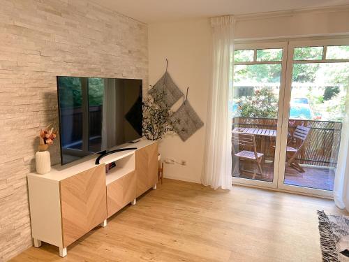 a living room with a flat screen tv on a dresser at Red Rock Apartments - mit Parkplatz, Küche und Netflix in Trier