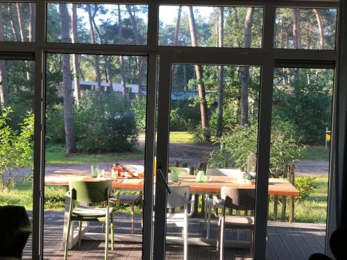 a table and chairs sitting on a screened in porch at Natuurhuisje Pine & Oak 6 persoons in Hardenberg