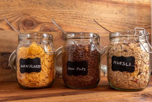 three glass jars filled with different types of grains at B&B El Lares - B&B L'Avez in Canale dʼAgordo