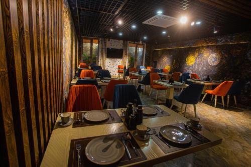 jadalnia ze stołami i krzesłami w restauracji w obiekcie Florence Boutique Hotel by Hotel Pro group w mieście Yakkasaray