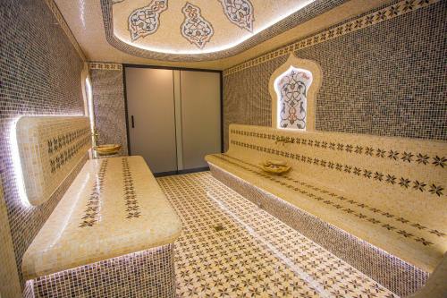 een badkamer met een bank en een betegelde muur bij Florence Boutique Hotel by Hotel Pro group in Yakkasaray