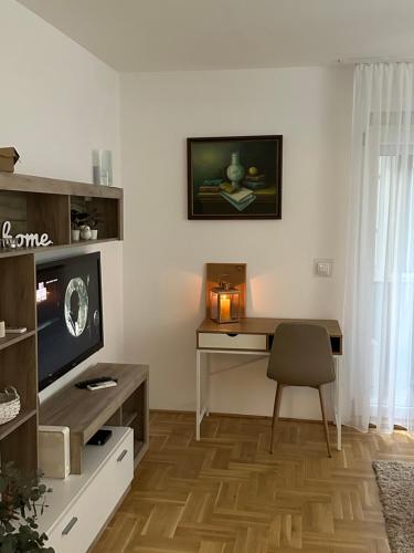 a living room with a desk and a television at Big White M in Karaburma