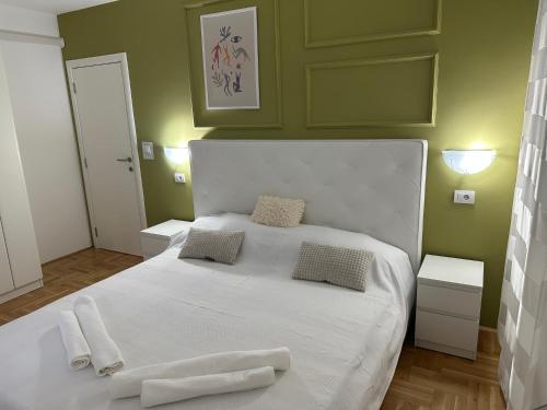 sypialnia z białym łóżkiem i 2 ręcznikami w obiekcie Big White M w mieście Karaburma