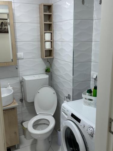 łazienka z toaletą i pralką w obiekcie Big White M w mieście Karaburma