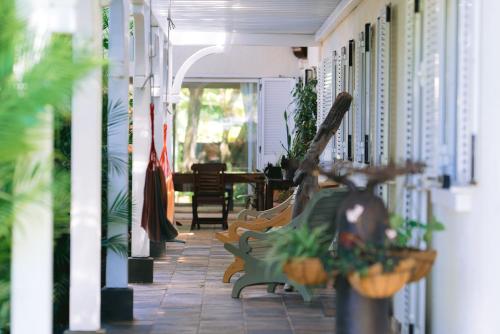 a porch with benches and plants on a house at Tree Lodge Mauritius Villa in Argy