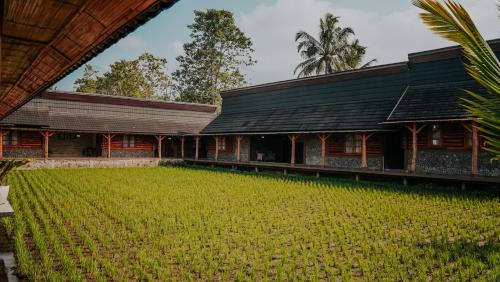 a house with a large field in front of it at Villa Rancabango Hotel & Resort Garut in Tarogong