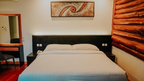 a bedroom with a large bed with a wooden headboard at Villa Rancabango Hotel & Resort Garut in Tarogong
