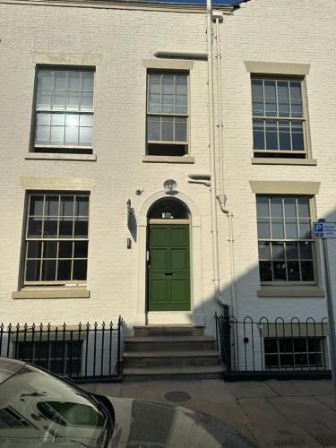 a green door on a building with a fence at The Spring Bank APARTHOTEL in Preston