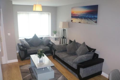 a living room with a couch and a table at Coleridge house Private parking NETFLIX in Swindon