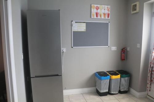 a refrigerator in a room with three trash cans at Coleridge house Private parking NETFLIX in Swindon