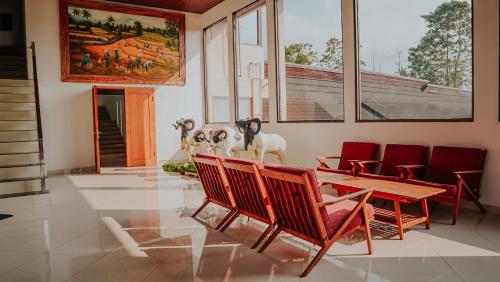 a dining room with red chairs and a wooden table at Villa Rancabango Hotel & Resort Garut in Tarogong
