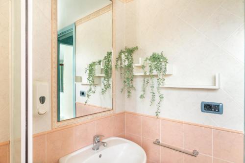 W łazience znajduje się umywalka i lustro. w obiekcie Museddu Beach Residence w mieście Cardedu
