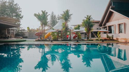 a pool at a resort with palm trees and a slide at Villa Rancabango Hotel & Resort Garut in Tarogong