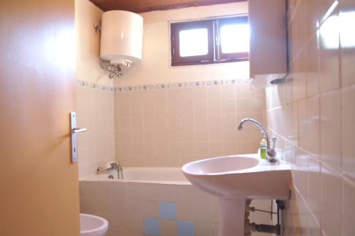 een badkamer met een wastafel en een bad bij Au coeur des Grand fond in Le Gosier