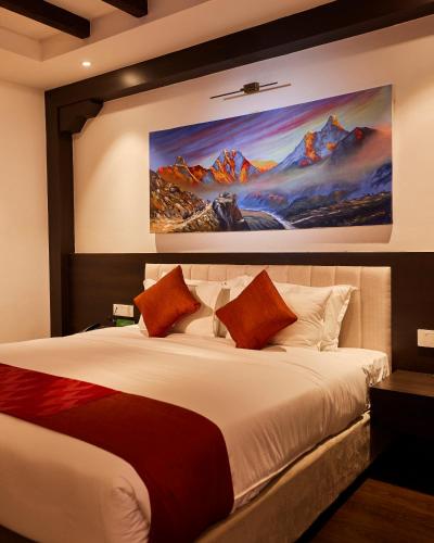 a bedroom with a large bed with a painting on the wall at Kantipur Village in Kathmandu