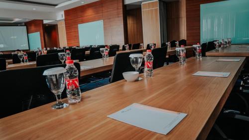 a conference room with a long wooden table with wine glasses at Villa Rancabango Hotel & Resort Garut in Tarogong