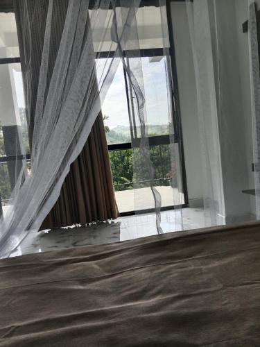 a bedroom with a bed and a large window at Ella glory inn in Ella