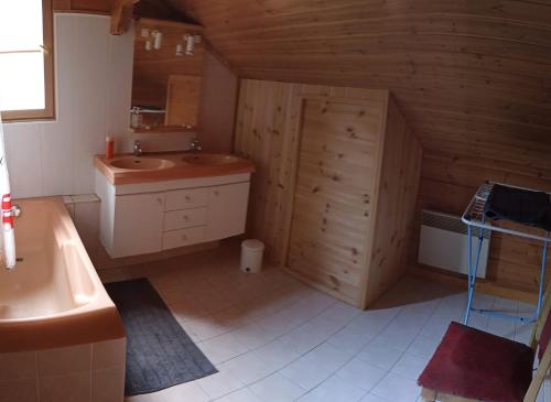 La salle de bains est pourvue d'un lavabo, de toilettes et d'une baignoire. dans l'établissement Spacieux Chalet, à Les Chapelles