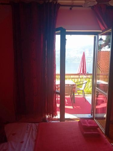 a bedroom with a door open to a patio with a view at Guest House Cinderella in Herceg-Novi