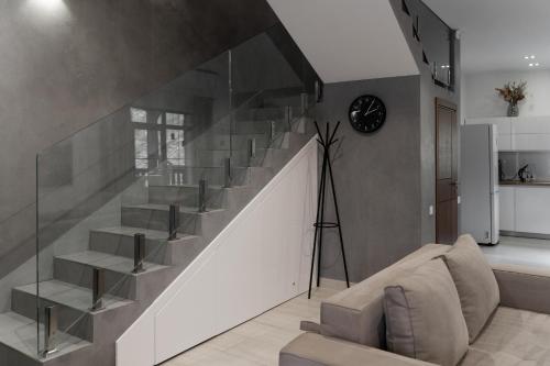 a staircase in a living room with a clock on the wall at Mal'ovanka in Bukovel