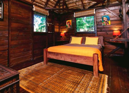 a bedroom with a bed in a wooden cabin at Tree Lodge Mauritius Villa in Argy