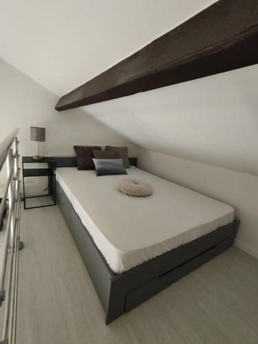 Cette chambre comprend un grand lit avec un cadre de lit. dans l'établissement Studio jardin Piscine climatisatisation accès plage, à Saint-Raphaël