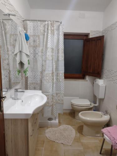 een badkamer met een wastafel, een toilet en een douche bij Dolce casa in Gonnesa