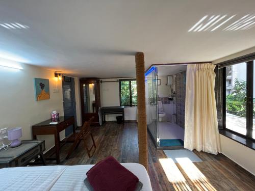 - une chambre avec un lit, un bureau et une salle de bains dans l'établissement Bella, à Mumbai