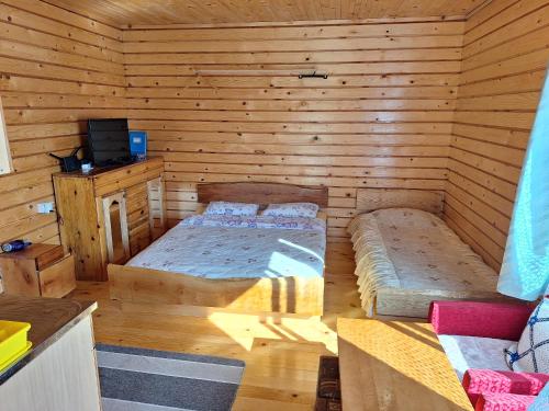 a bedroom with two beds in a log cabin at Kolibe Ćorić in Mojkovac