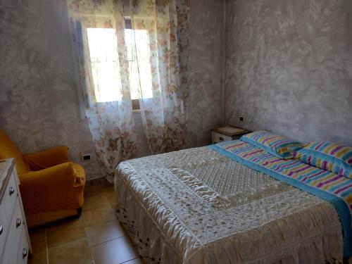 een kleine slaapkamer met een bed en een raam bij Dolce casa in Gonnesa