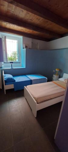 ein blaues Schlafzimmer mit 2 Betten und einem Fenster in der Unterkunft La Jeannotte in Levanto