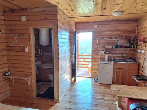 a kitchen with wooden walls and a wooden floor at Kolibe Ćorić in Mojkovac