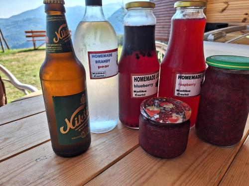 a wooden table with bottles of condiments on it at Kolibe Ćorić in Mojkovac