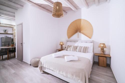 a white bedroom with a bed and a table at Studio Papadia in Pitsidia