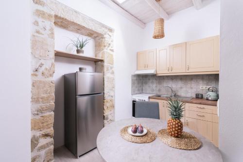 a kitchen with a round table with a refrigerator at Studio Papadia in Pitsidia