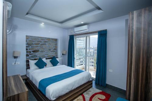 a bedroom with a bed and a large window at Chautari Boutique Hotel in Pokhara