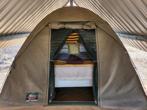 a small tent with a bed in it at Jackal Cry River View Tent in Skeerpoort