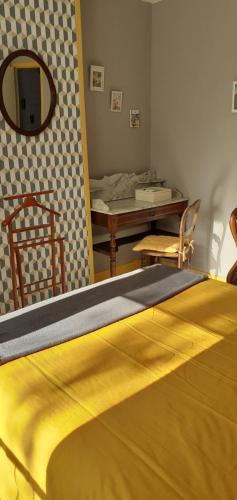 een bed in een kamer met een tafel en een spiegel bij Chez sylvie in Soyaux