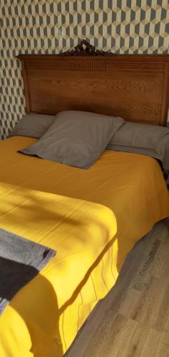 een bed met een geel dekbed in een kamer bij Chez sylvie in Soyaux
