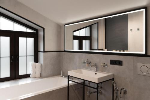 a bathroom with a sink and a tub and a mirror at Sherwood Chalet in Bukovel