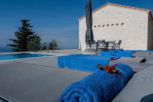 a pool with a blue blanket next to a table and chairs at SAPPHIRE AGIOS NIKITAS in Drymon
