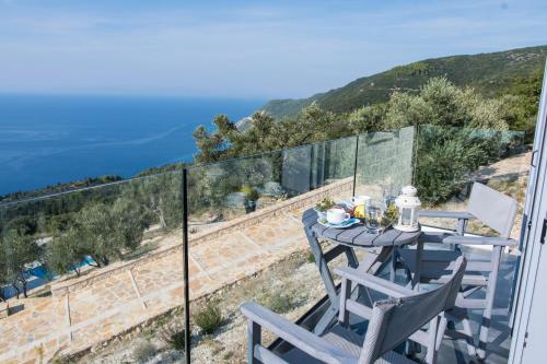a table and chairs on a balcony with a view of the ocean at SAPPHIRE AGIOS NIKITAS in Drymon