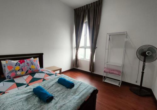 a bedroom with a bed with blue pillows on it at 2R2B Comfy Homestay, 1-6 Pax - GA4 in Shah Alam