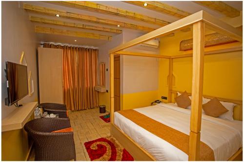 a bedroom with a canopy bed and a television at Chautari Boutique Hotel in Pokhara