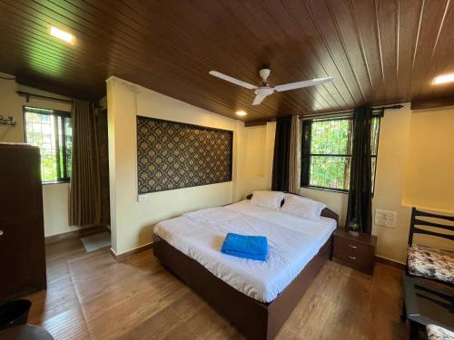 a bedroom with a bed with a blue pillow on it at Rocky in Mumbai